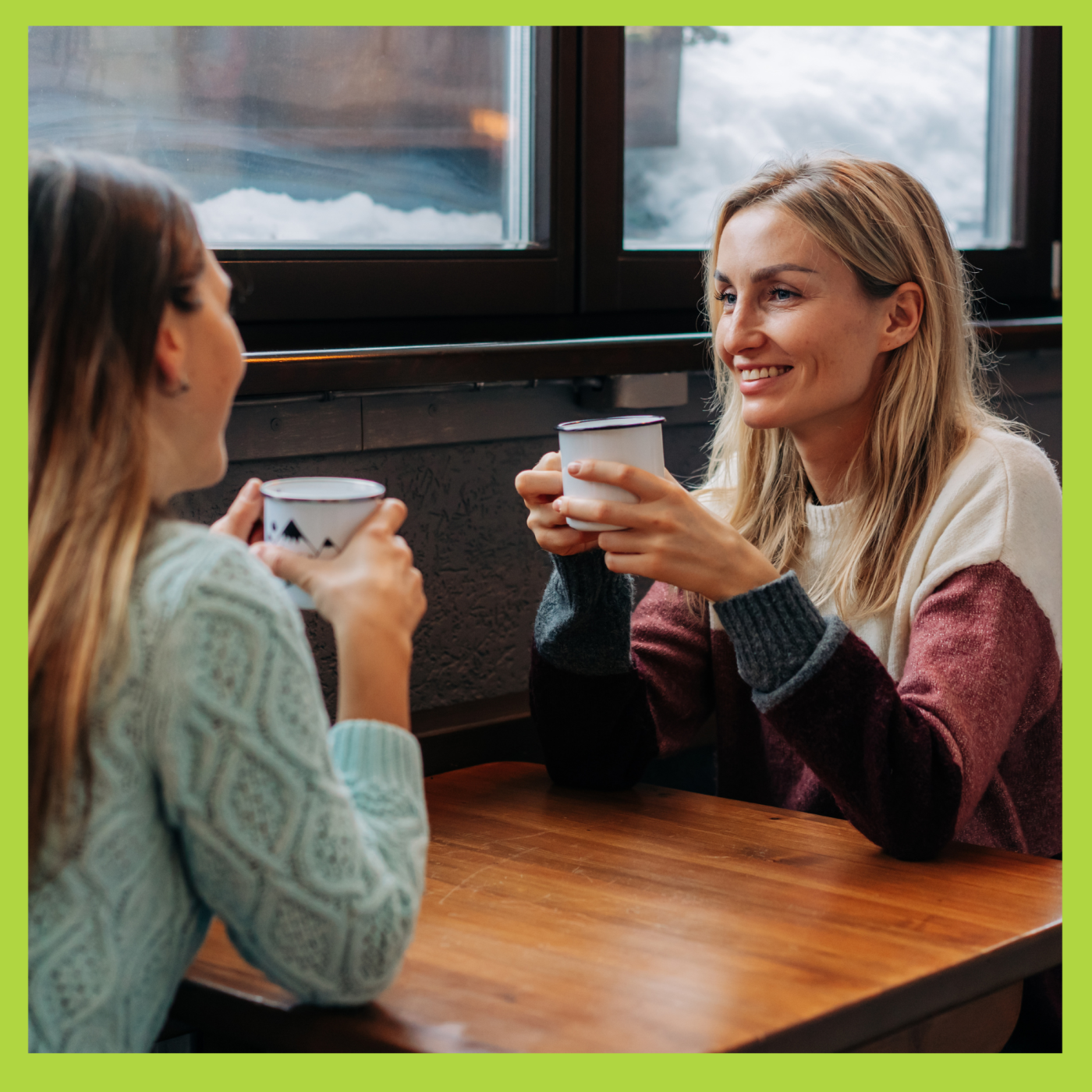 An adult woman and a teenage girl having coffee in a cafe